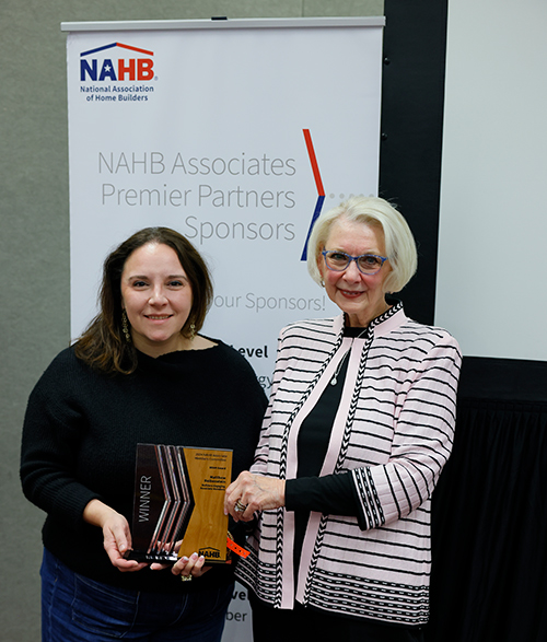 two women smiling holding 2025 associates of excellence award