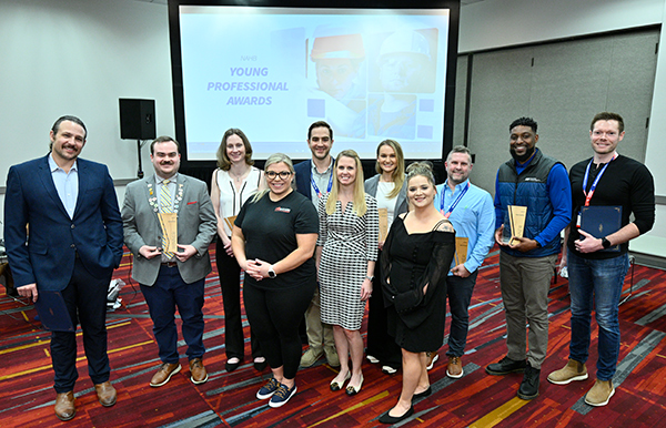 group of men and women holding their young professional awards