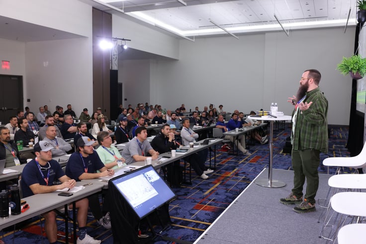 A presenter speaks to the crowd at the Building Science Symposium
